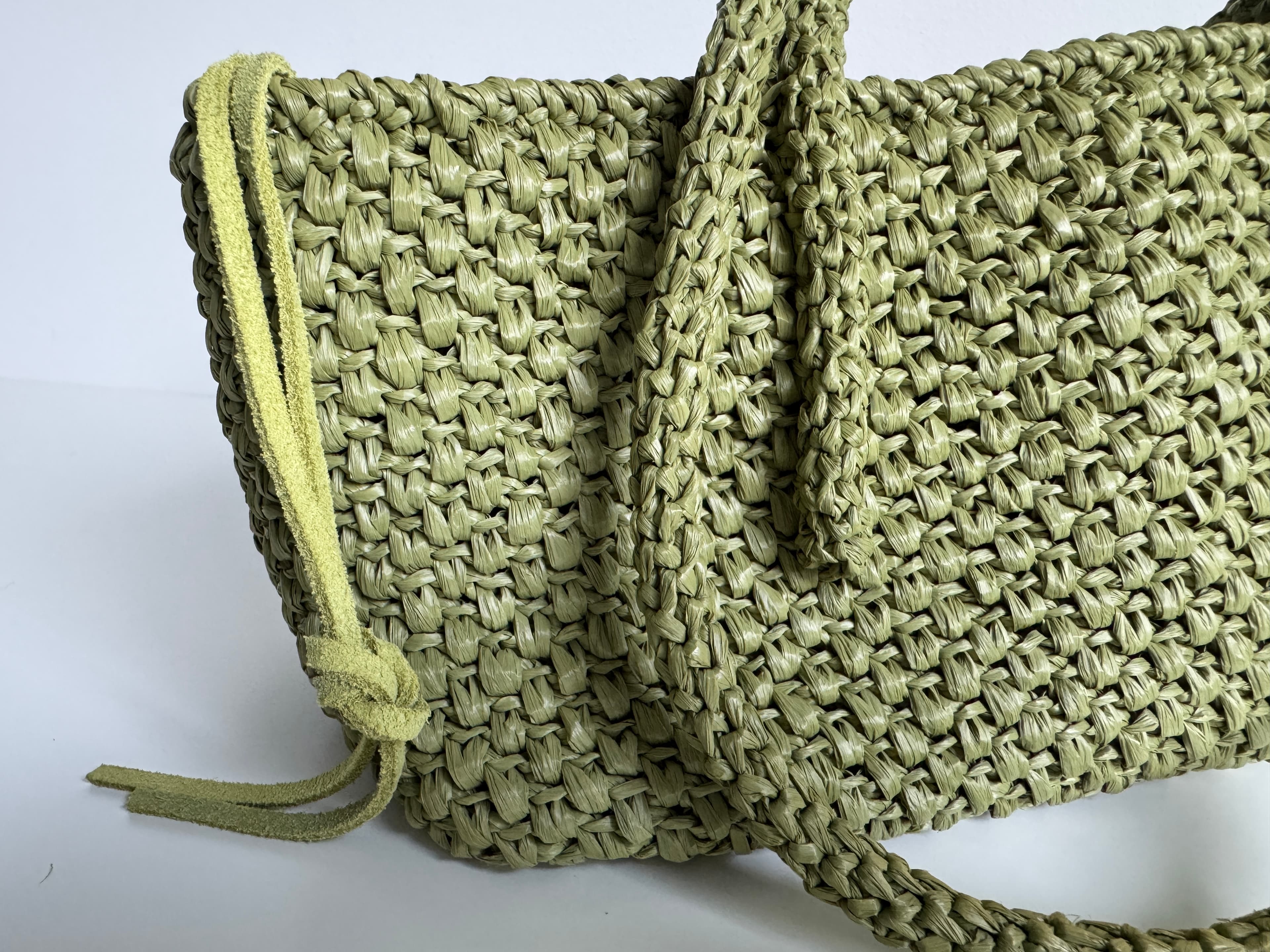 Sac à main en raphia tressé vert olive avec anses épaisses et cordon en daim.
