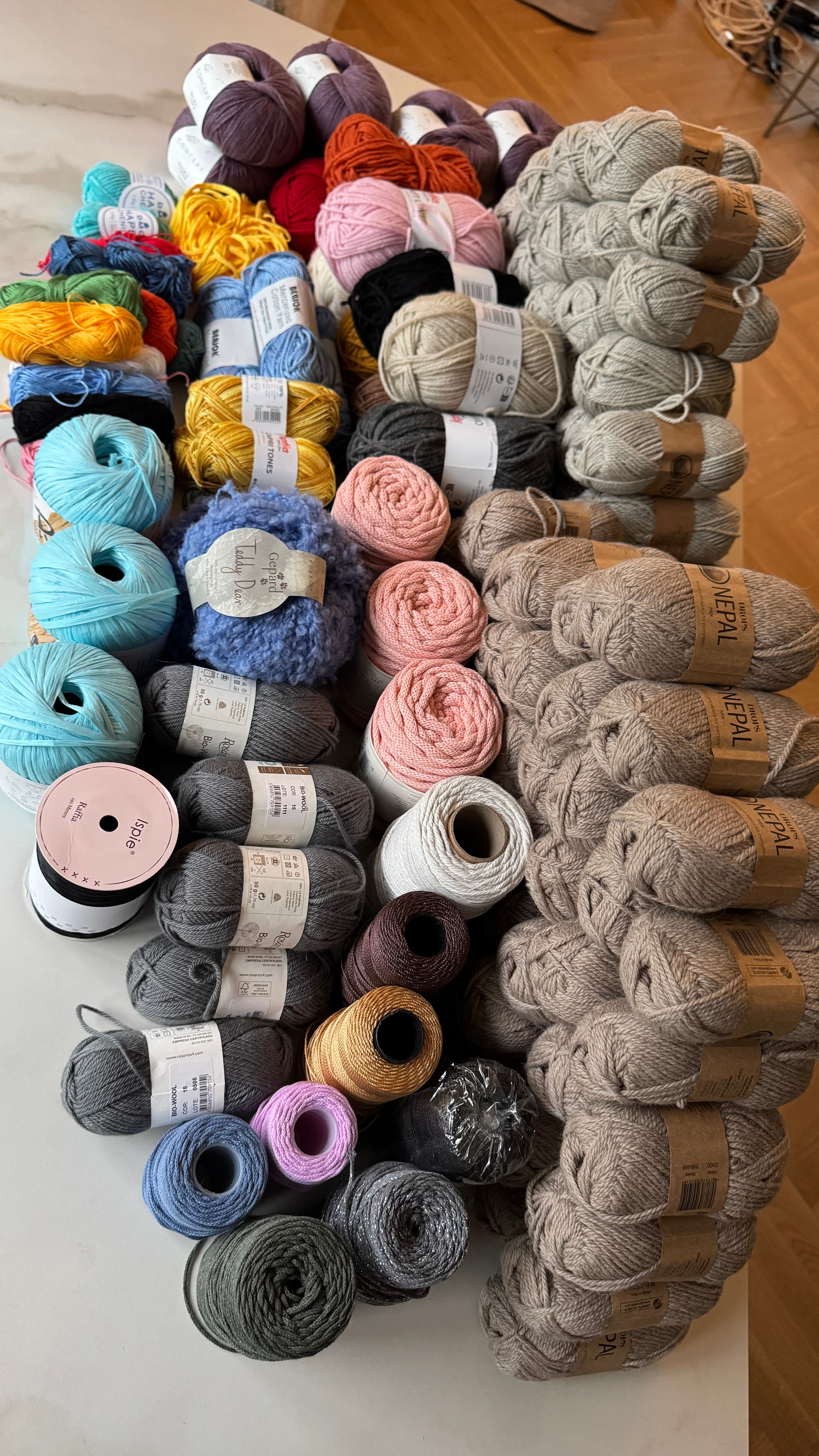 Une grande collection de pelotes de laine colorées de différentes textures et tailles.